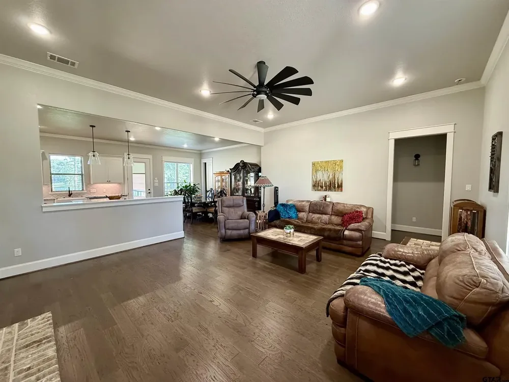 Open concept living room with brick fireplace and engineered wood floors at 644 An County Road 3009 on Lake Palestine in Frankston TX