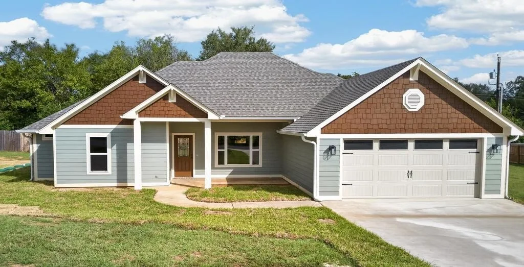 Front of 281 ACR 308 with blue siding, shake-style gables and an attached garage.