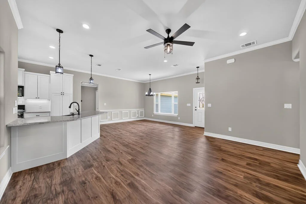 Open living area looking toward the kitchen peninsula and front door at 281 ACR 308.