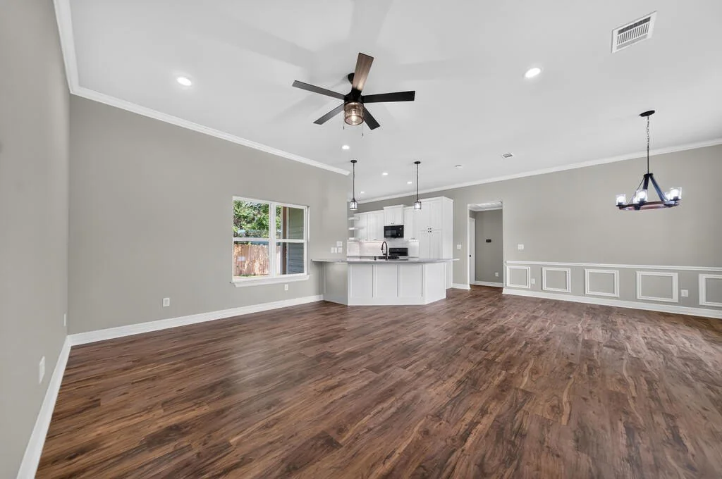 Open living and dining area with a ceiling fan and wood-look plank floors at 281 ACR 308.