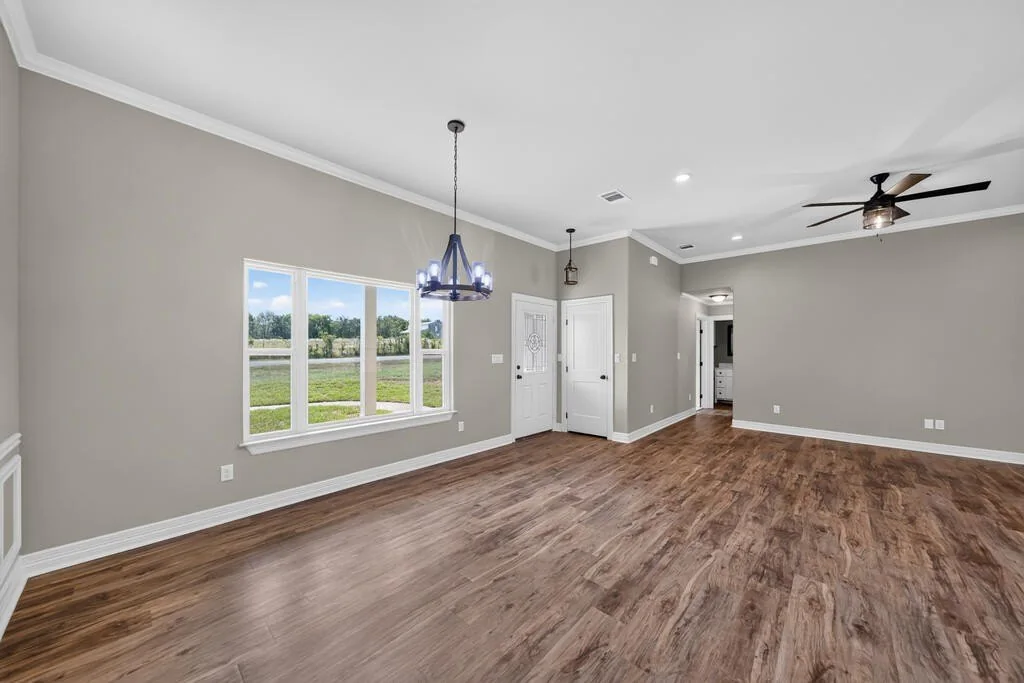 Dining area with a large front window, looking toward the front door and hallway at 281 ACR 308.
