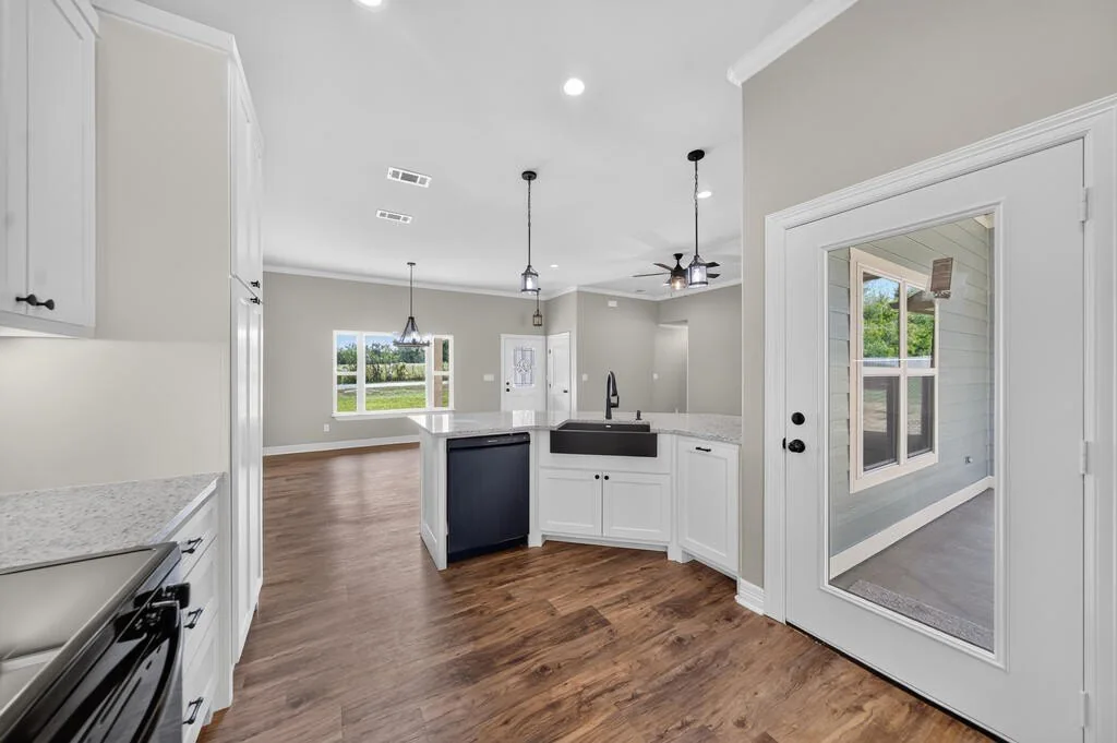 Kitchen looking toward the living area, with the dishwasher and farmhouse-style sink in the peninsula at 281 ACR 308.