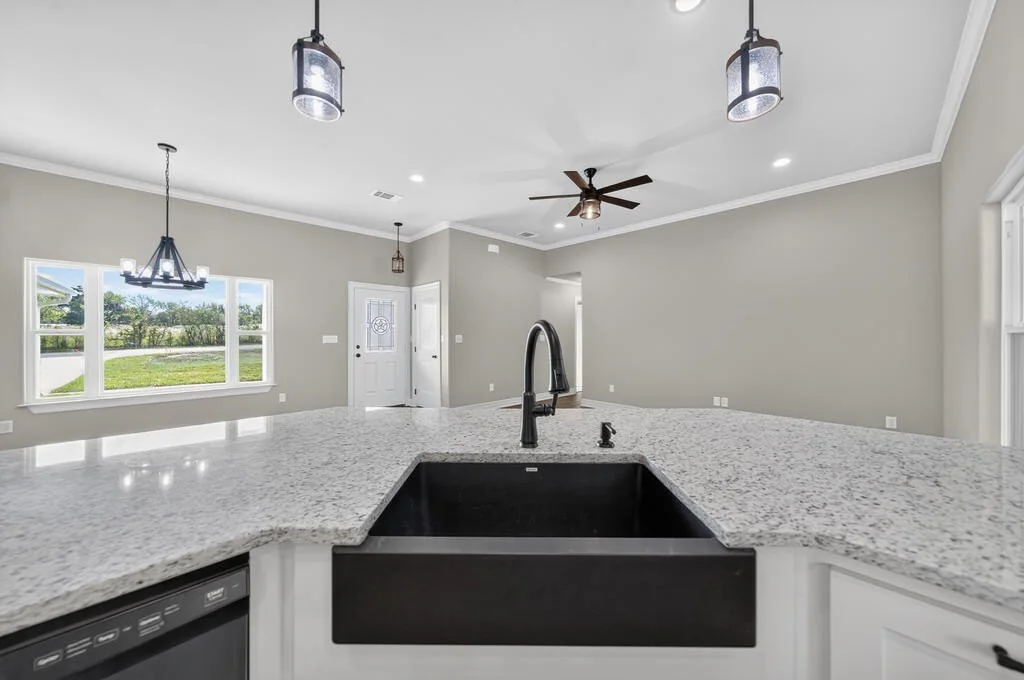 Black farmhouse-style sink set into the granite peninsula at 281 ACR 308.