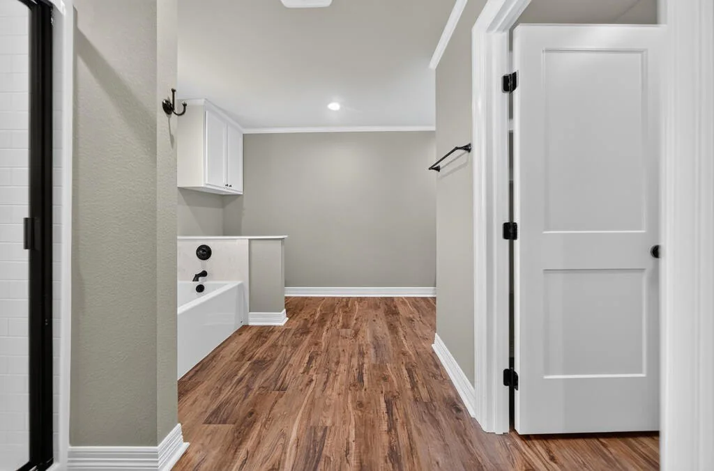 Bathroom with a soaking tub and wood-look floors at 281 ACR 308.