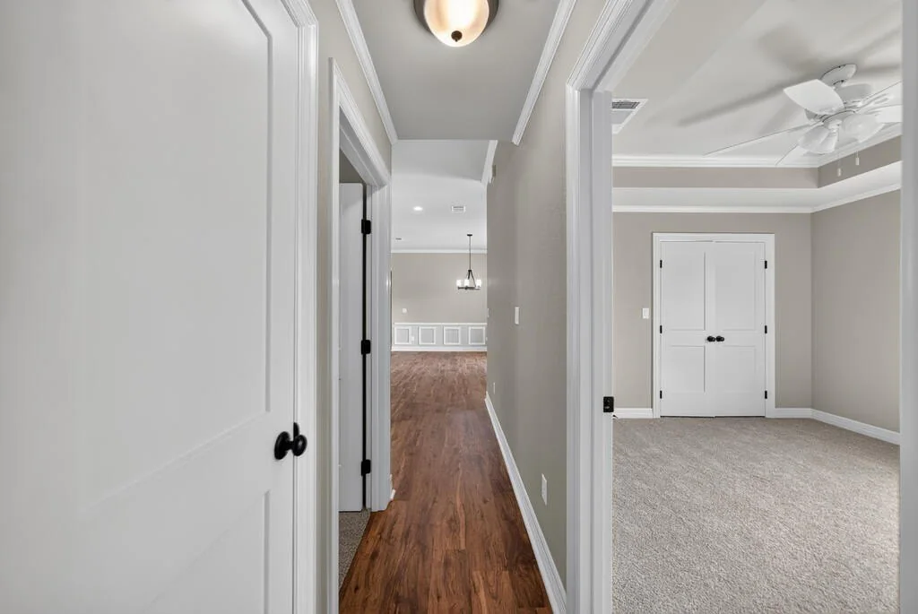 Hallway with a doorway into a carpeted bedroom with double closet doors at 281 ACR 308.