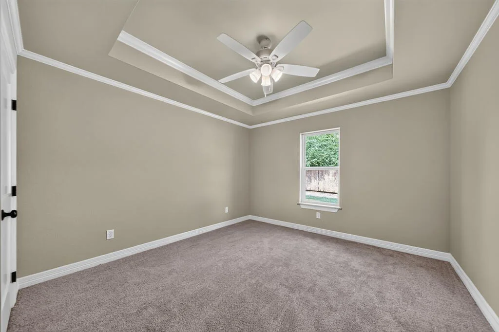 Carpeted bedroom with a tray ceiling and a single window at 281 ACR 308.