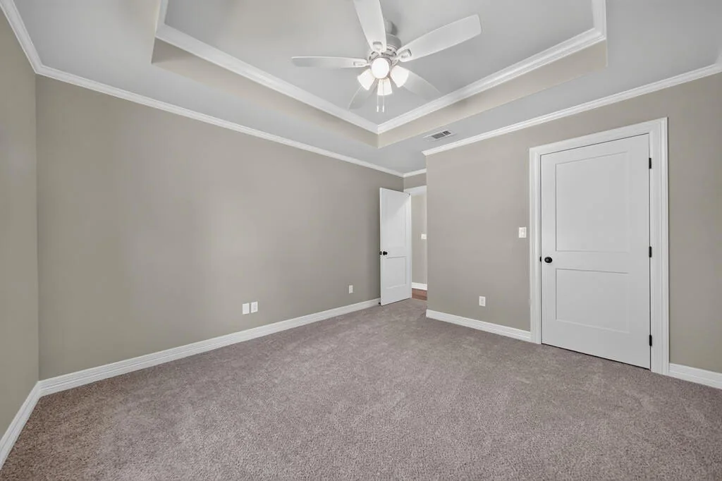 Carpeted bedroom with a tray ceiling and a closet at 281 ACR 308.