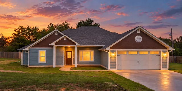 Front of the new home at 281 ACR 308 in Frankston, TX, at twilight with the lights on.