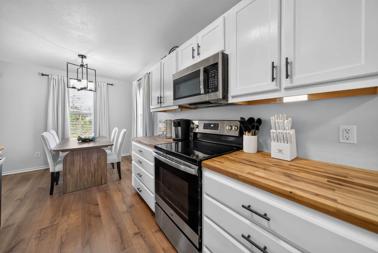 Kitchen with white cabinets and stainless steel appliances at 1054 Caroline Ln in Shadybrook, a gated Lake Palestine community in Bullard, TX.