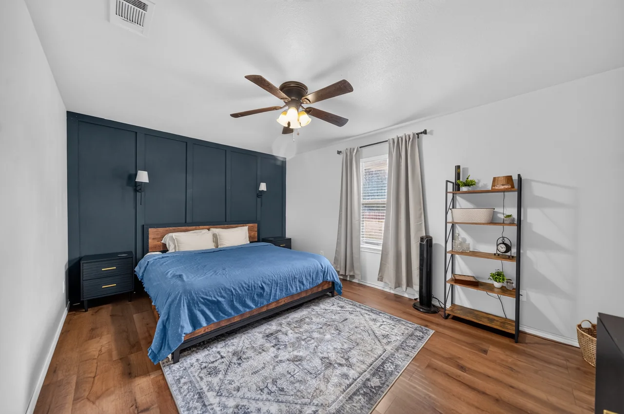 Primary bedroom with a navy board-and-batten accent wall at 1054 Caroline Ln in Shadybrook, a gated Lake Palestine community in Bullard, TX.