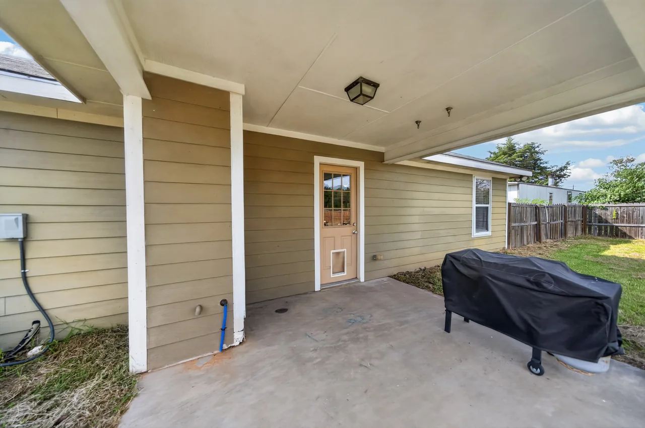 Covered back porch off the back door at 1054 Caroline Ln in Shadybrook, a gated Lake Palestine community in Bullard, TX.