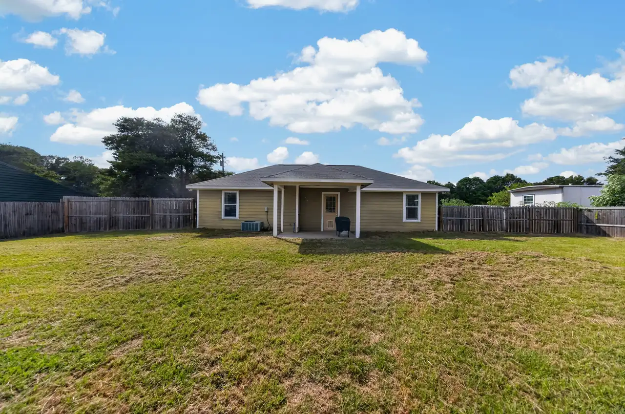 Large backyard enclosed by a wood privacy fence at 1054 Caroline Ln in Shadybrook, a gated Lake Palestine community in Bullard, TX.
