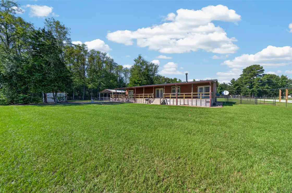 Open lawn beside the home and its long covered deck at 21138 County Road 4202 in Chandler, TX, across from Brown's Landing on Lake Palestine.