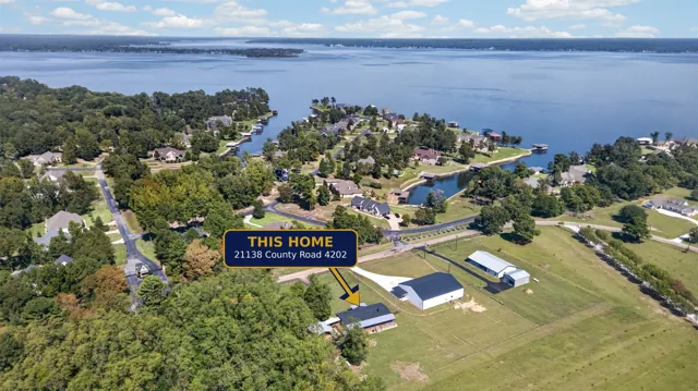 Aerial view with an arrow and label marking the home for sale on its fenced acre, with Lake Palestine beyond, at 21138 County Road 4202 in Chandler, TX, across from Brown's Landing on Lake Palestine.