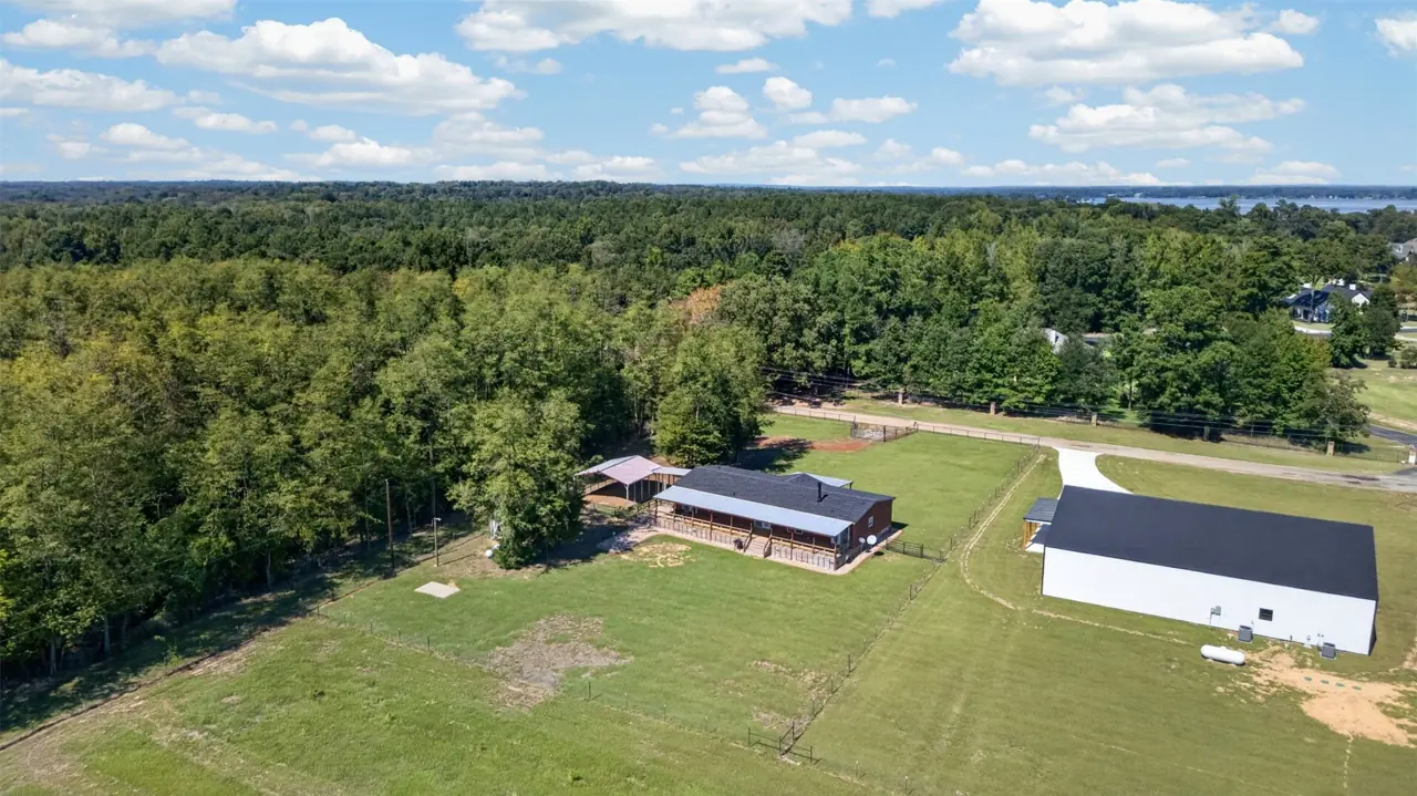 Aerial view of the home, fenced pasture and tree line at 21138 County Road 4202 in Chandler, TX, across from Brown's Landing on Lake Palestine.