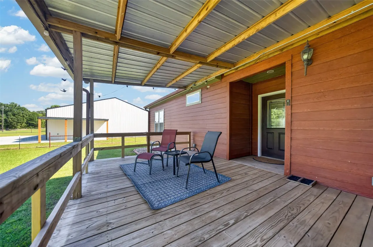 Covered front porch with seating outside the front door at 21138 County Road 4202 in Chandler, TX, across from Brown's Landing on Lake Palestine.