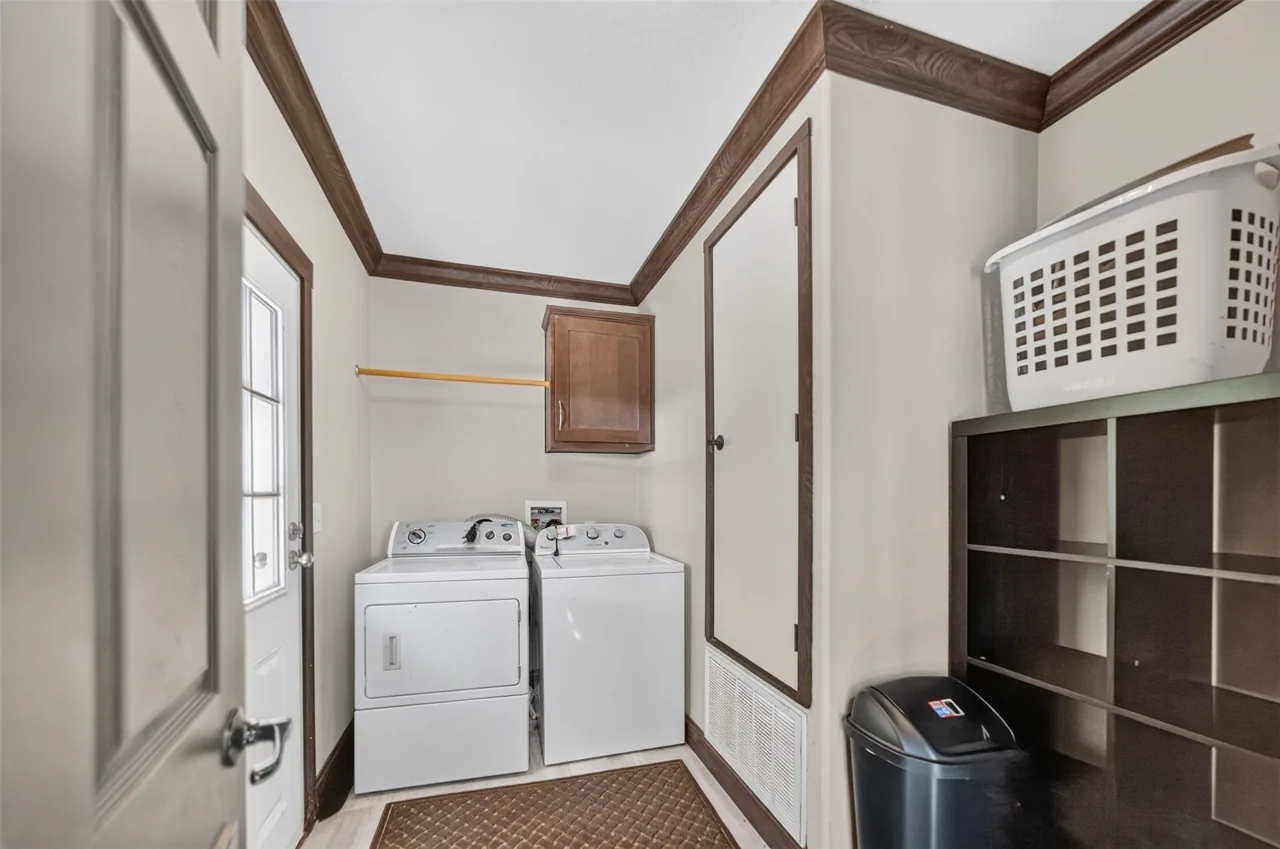 Laundry room with washer, dryer and shelving at 21138 County Road 4202 in Chandler, TX, across from Brown's Landing on Lake Palestine.