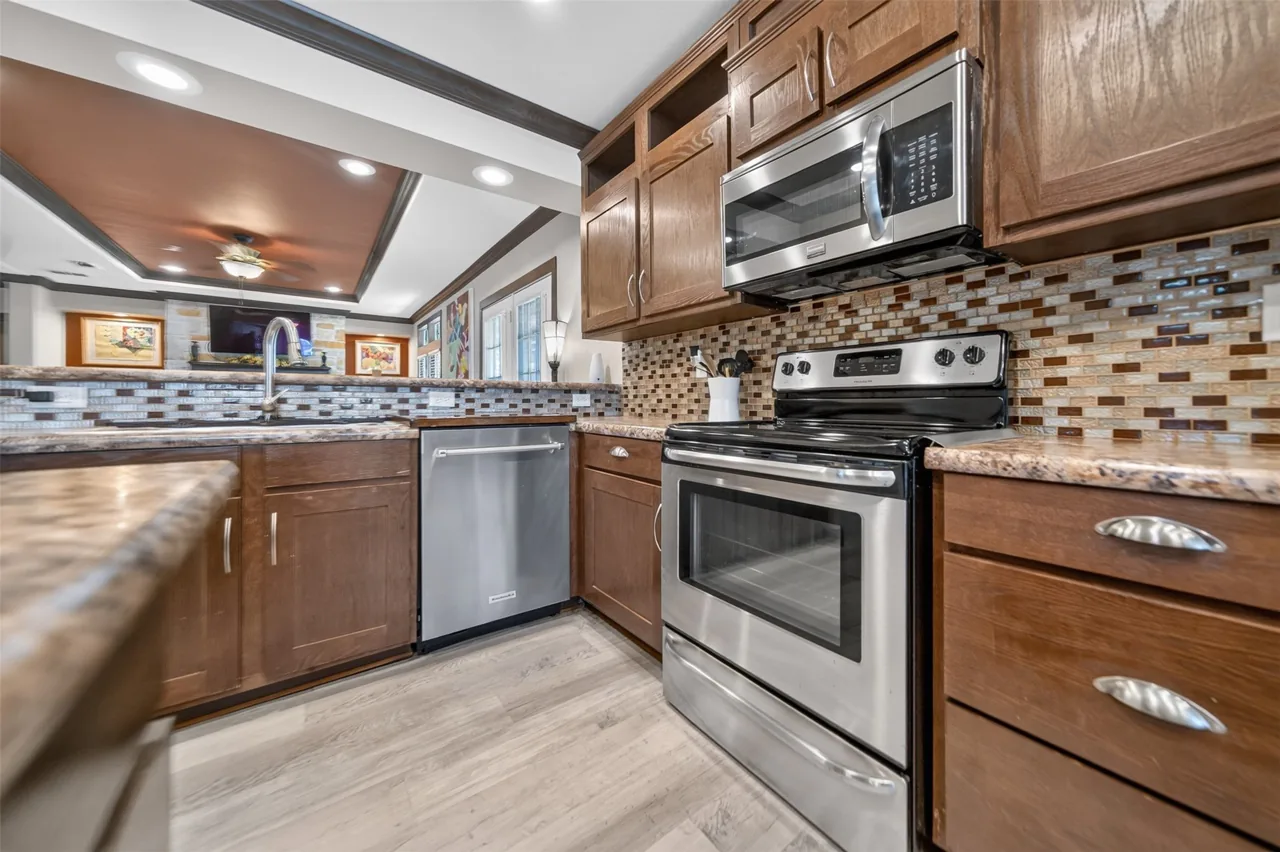 Kitchen range, microwave, dishwasher and tile backsplash at 21138 County Road 4202 in Chandler, TX, across from Brown's Landing on Lake Palestine.