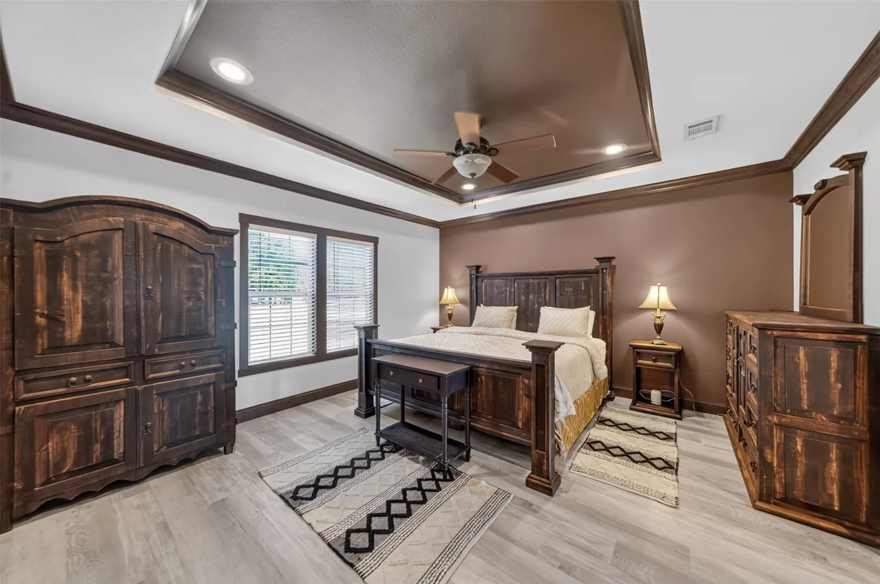 Primary bedroom with a tray ceiling and ceiling fan at 21138 County Road 4202 in Chandler, TX, across from Brown's Landing on Lake Palestine.