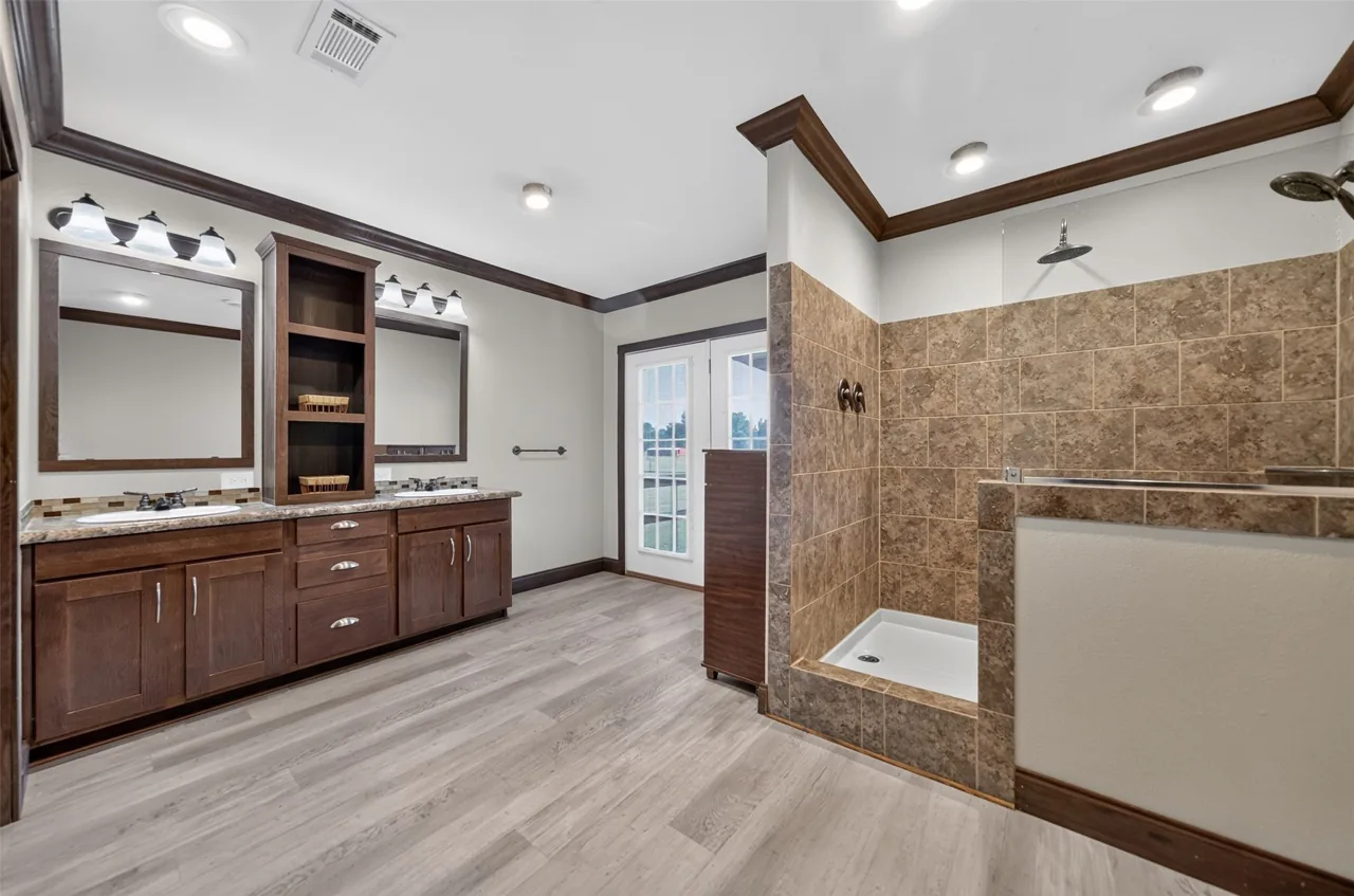 Primary bathroom double vanity and walk-in shower at 21138 County Road 4202 in Chandler, TX, across from Brown's Landing on Lake Palestine.