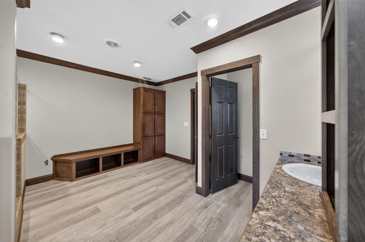 Built-in bench and linen cabinet in the primary bathroom at 21138 County Road 4202 in Chandler, TX, across from Brown's Landing on Lake Palestine.