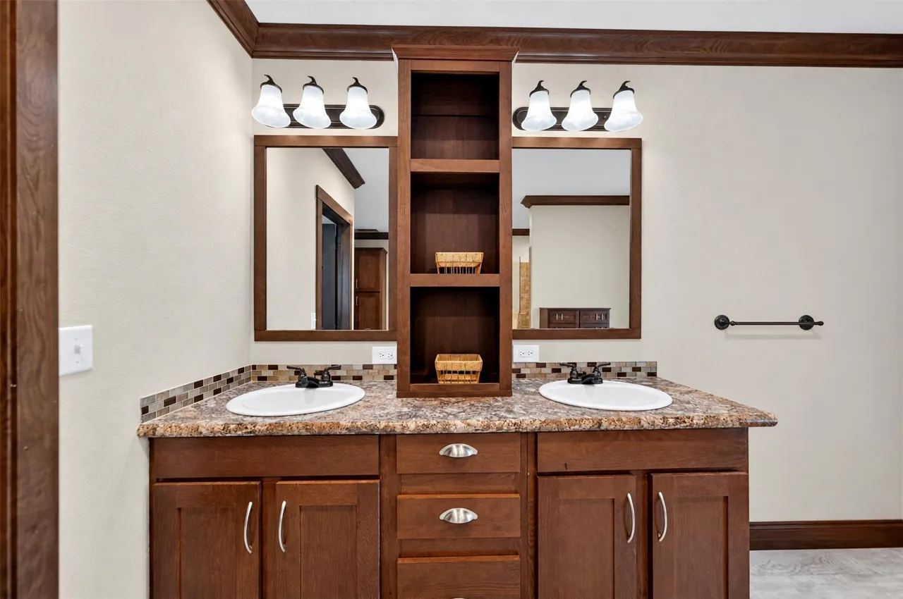 Primary bathroom double vanity with a center shelf tower at 21138 County Road 4202 in Chandler, TX, across from Brown's Landing on Lake Palestine.