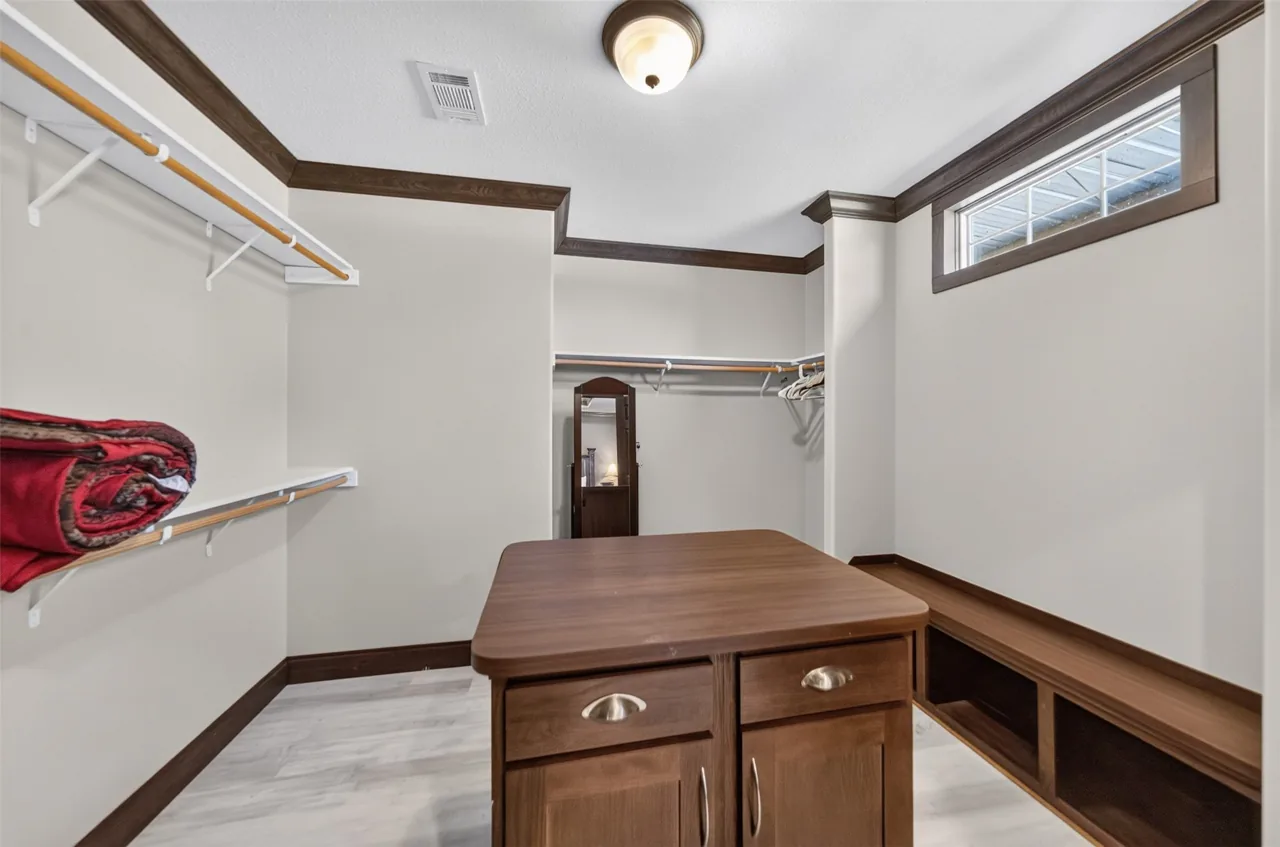 Primary walk-in closet with a center island and built-in bench at 21138 County Road 4202 in Chandler, TX, across from Brown's Landing on Lake Palestine.
