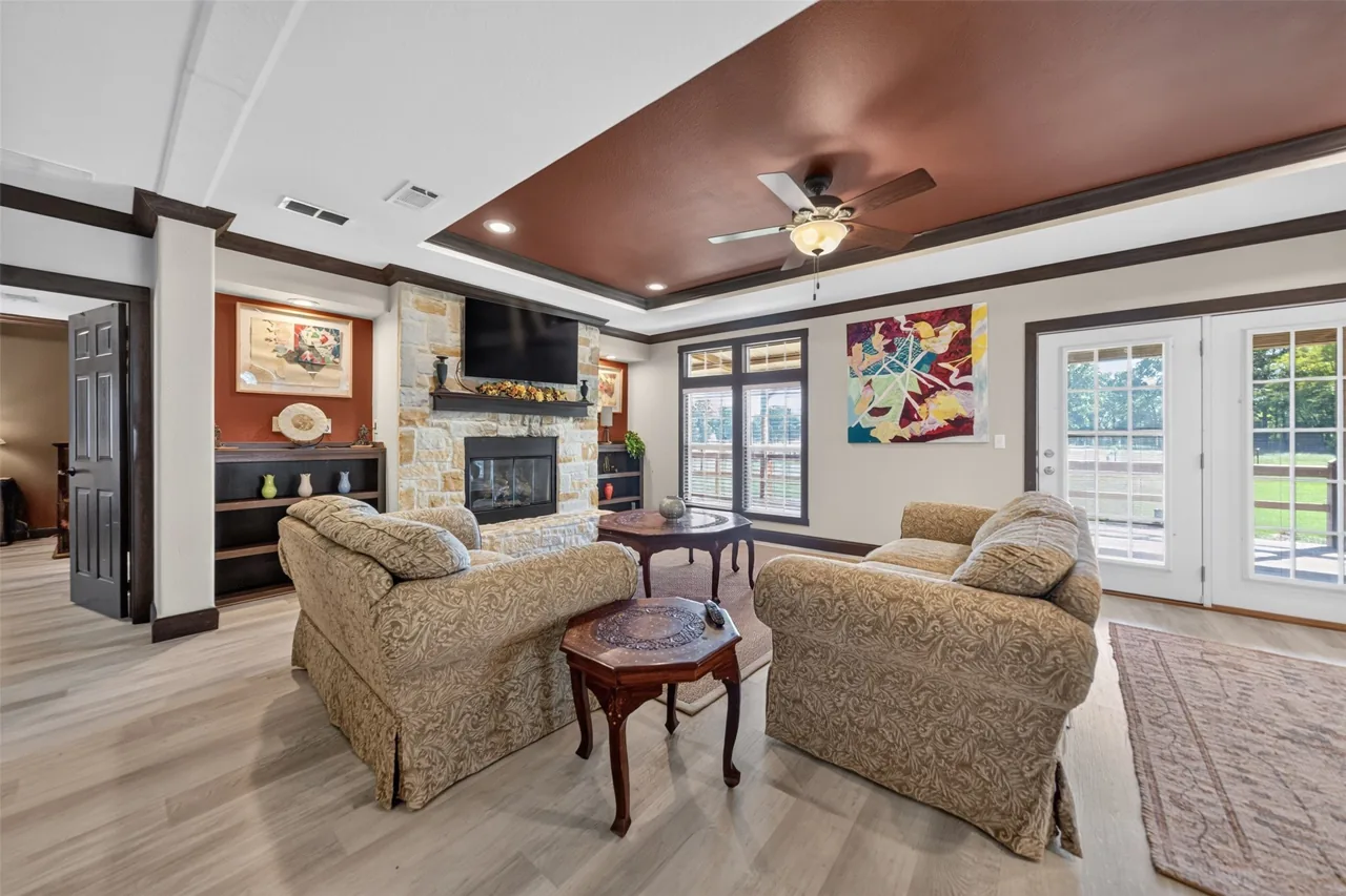 Living room with an Austin stone gas fireplace and French doors at 21138 County Road 4202 in Chandler, TX, across from Brown's Landing on Lake Palestine.