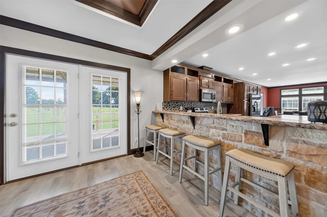 Stone-faced breakfast bar with stools beside French doors at 21138 County Road 4202 in Chandler, TX, across from Brown's Landing on Lake Palestine.