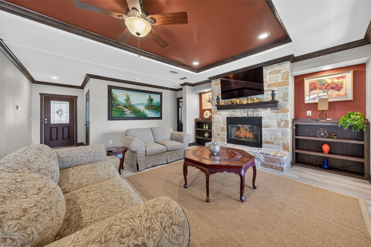 Living room seating area facing the stone fireplace at 21138 County Road 4202 in Chandler, TX, across from Brown's Landing on Lake Palestine.