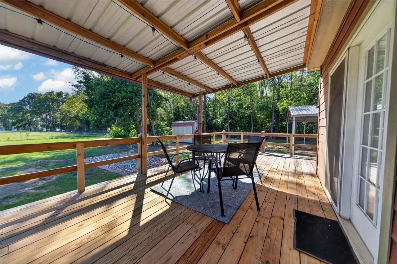 Seating area on the covered deck beside French doors at 21138 County Road 4202 in Chandler, TX, across from Brown's Landing on Lake Palestine.