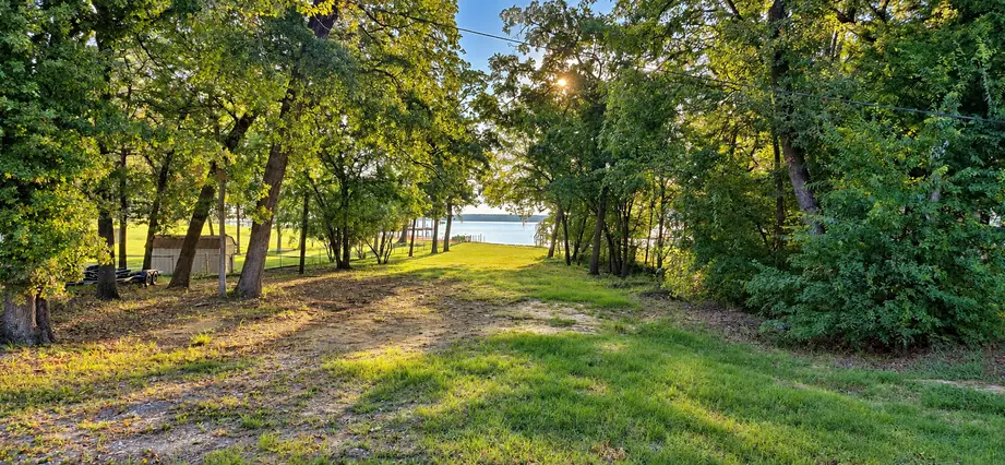 Street view of the Lake Palestine waterfront lot at 22693 Creekwood Dr in Lakeway Harbor, Flint TX, with the lake visible through the trees.