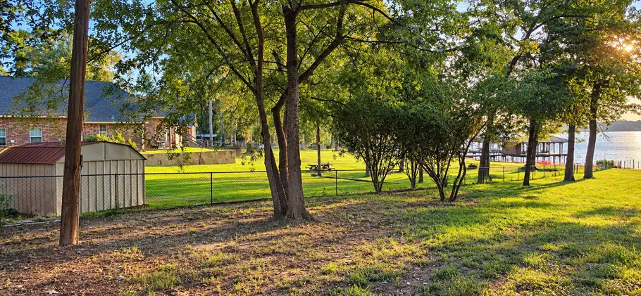 Right side of the waterfront lot at 22693 Creekwood Dr looking toward Lake Palestine, with neighboring boathouses in the distance.
