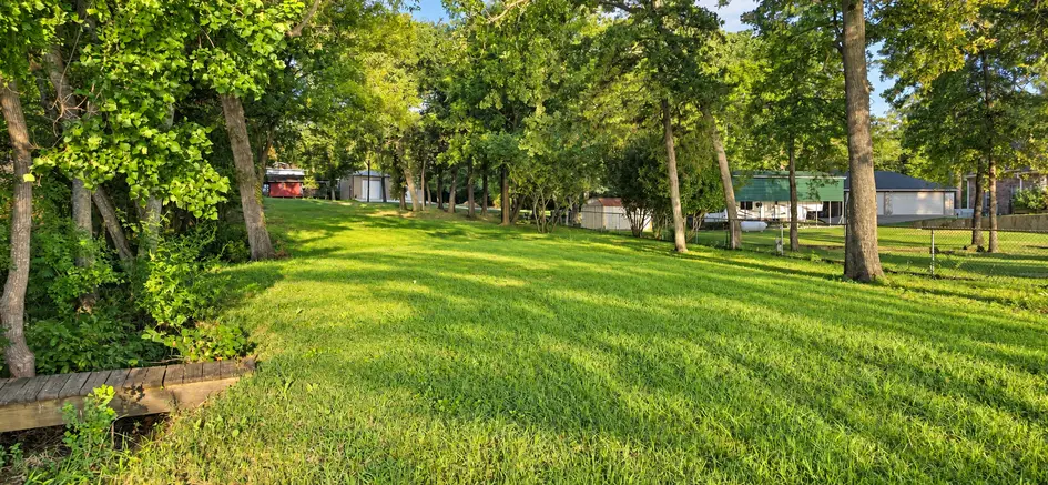The left side of the lot at 22693 Creekwood Dr in Lakeway Harbor, looking up toward Creekwood Drive.