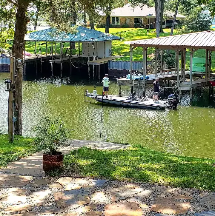 A calm, sheltered cove on Lake Palestine with private boathouses and a bass boat, at the Lake Palestine Bungalow.